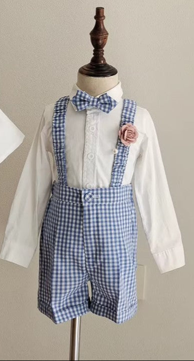 Front view of the blue gingham boy wedding outfit featuring adjustable suspenders, bow tie, tailored shorts, and a blush floral pin. Perfect for formal events.