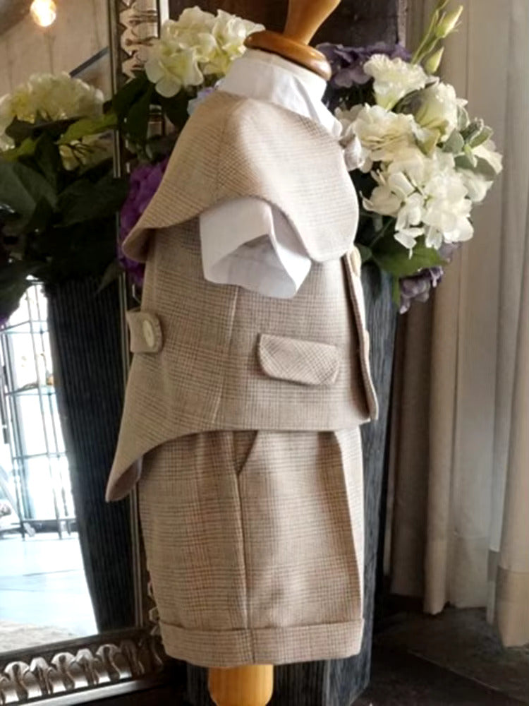Side view of a vintage baby boy wedding suit in beige houndstooth fabric, featuring a double-breasted vest, cape, bow tie & shorts. Perfect for page boys & christenings.