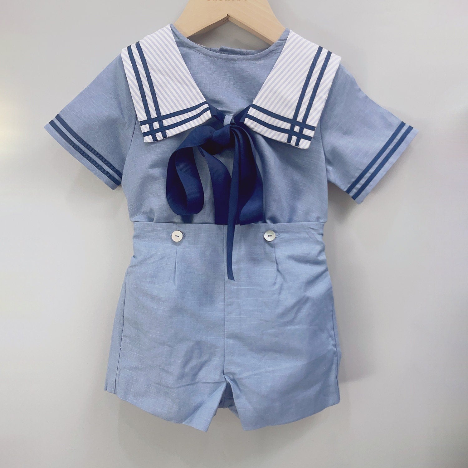 Classic sailor boys' outfit in light blue with a nautical collar, ribbon tie, and high-waisted shorts, perfect for christenings, birthdays, and weddings for boys aged 12 months to 6 years.