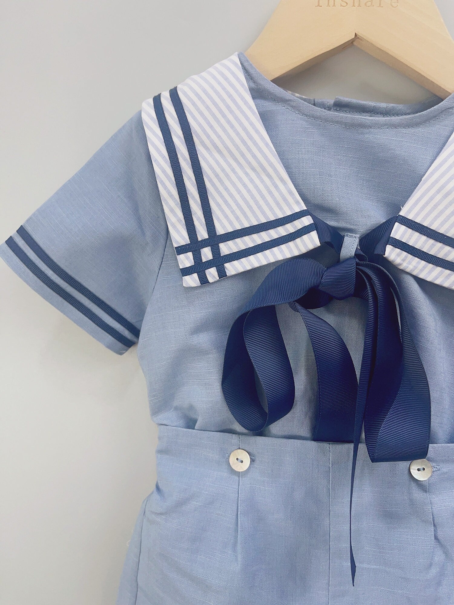 Close-up front view of the classic sailor-style boys' outfit, featuring a nautical collar, navy ribbon tie, and light blue high-waisted shorts, perfect for special occasions like birthdays, christenings, and weddings for boys aged 12 months to 6 years